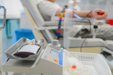 Donörün kolu bir makineye bağlı, tıbbi tedavi için torbada kan topluyor ve hayat kurtarıyor. Bağışa odaklan