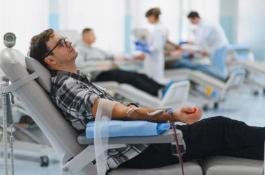 Tıp kürsüsünde otururken kan bağışı yapmak, sağlık hizmetlerine katkıda bulunmak ve klinikte başkalarına yardım etmek