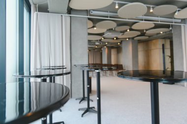 Yüksek kokteyl masaları ve sandalyelerle kurulmuş modern konferans salonu, kurumsal bir ağ etkinliği ya da toplanma için hazır.