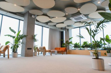 Çağdaş tasarım, büyük pencereler, akustik tavan panelleri ve rahatlatıcı bir atmosfer yaratan verimli saksı bitkilerinin yer aldığı geniş kapalı lobiler.