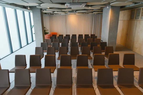 Konferans salonu içi boş koltukları gösteriyor, kurumsal seminer veya sunum etkinliği için hazır.