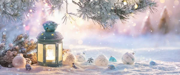 Linterna de Navidad en la nieve con rama de abeto en la luz del sol — Foto de Stock