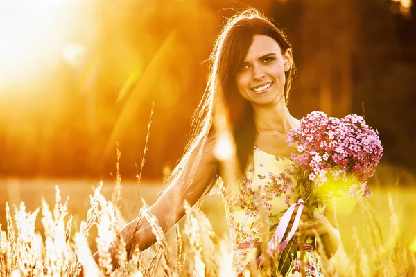 Vacker flicka med blommor — Stockfoto