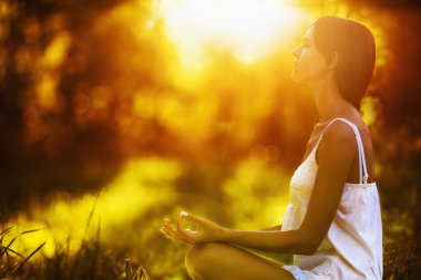 Yoga woman meditating at sunset clipart