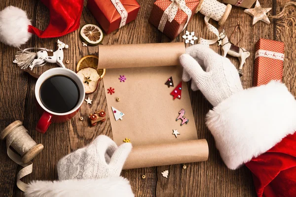 Santa Claus con regalos y lista de deseos — Foto de Stock
