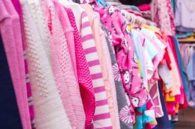 Mağazadaki satış tezgahında asılı duran güzel kadın kıyafetleri.