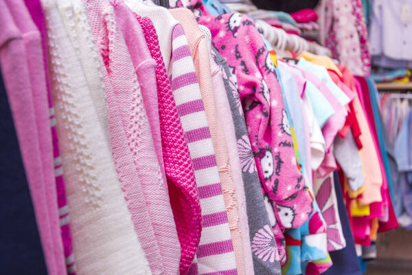 Красивая летняя женская одежда висит на вешалках у прилавка в магазине