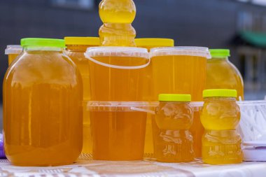 Bashkir arısı balı sonbahar fuarında satılmak üzere farklı konteynırlara doldurulur..