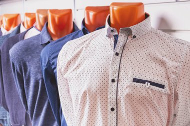 Manken gibi giyinmiş ve müşterilere satılmaya hazır yaz erkek gömleği örnekleri.