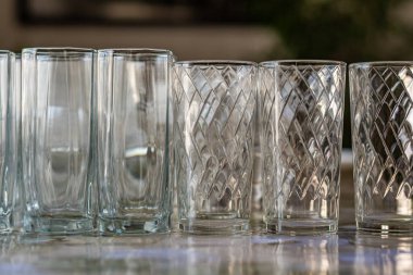 Boş cam kadehler koyu arkaplanda duruyor. 