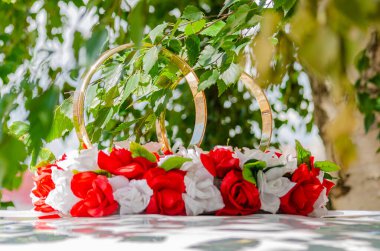 Yeni evlilerin arabası için düğün süslemeleri. İki altın yüzük ve huş ağacının yeşil yapraklı parlak çiçekler. 