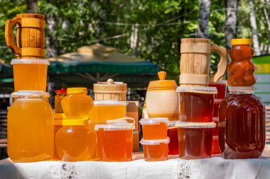 Masada kavanozlar ve bal dolu plastik kaplar var ve bal fuarında satılmaya hazır..