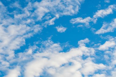 Küçük beyaz kümülüs bulutları mavi yaz gökyüzünde süzülür. Sessiz gün.