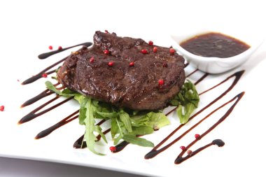 Beyaz tabakta az pişmiş biftek.