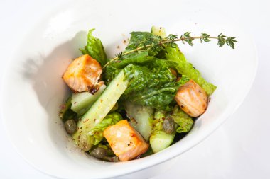 Tütsülenmiş somon salatası ve derin tabakta otlar.