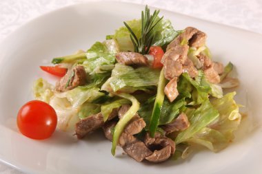 plaka üzerinde et salata yeşillikleri ile