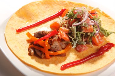 Mısır ekmeğine et ve marul soslu tortilla.