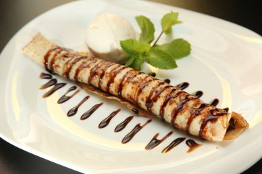 Çikolata soslu krep ve tabakta dondurma.