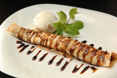 Çikolata soslu krep ve tabakta dondurma.