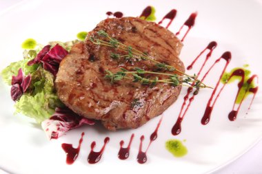 Tabağında sos olan bir et parçası.