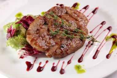 Tabağında sos olan bir et parçası.