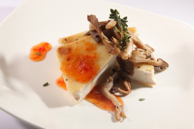 Beyaz tabakta mantarlı güveç.