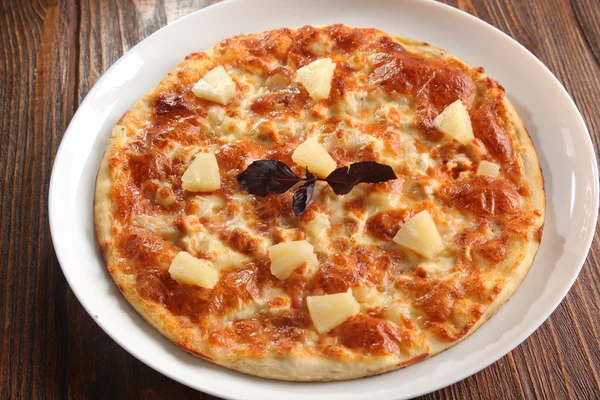 Pizza with pineapple on white plate