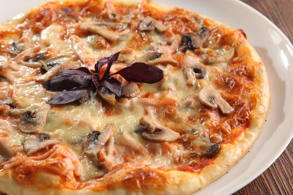 Pizza with mushrooms on white plate