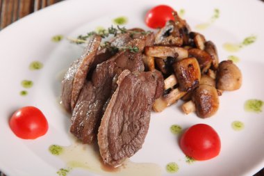 Mantarlı et parçaları ve tabakta pesto.