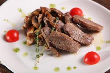 Mantarlı et parçaları ve tabakta pesto.