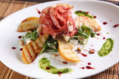 Izgara armutlu et ve tabakta pesto.