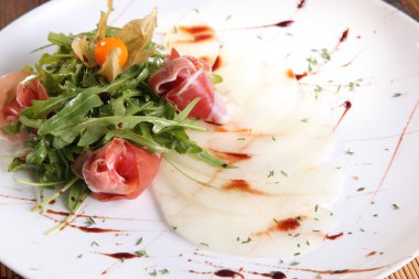 Arugula salatası ve tabakta kavun.