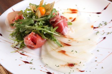 Arugula salatası ve tabakta kavun.