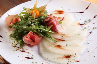 Arugula salatası ve tabakta kavun.