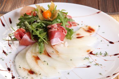 Arugula salatası ve tabakta kavun.