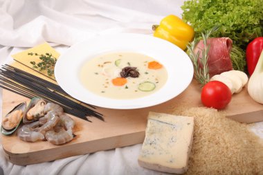 İtalyan sebze çorbası, tahtadan yapılmış taze yiyeceklerle çevrili.