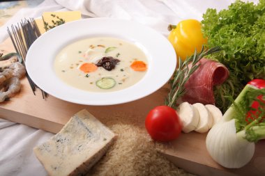 İtalyan sebze çorbası, tahtadan yapılmış taze yiyeceklerle çevrili.