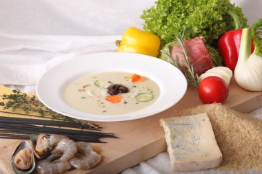 İtalyan sebze çorbası, tahtadan yapılmış taze yiyeceklerle çevrili.