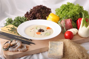 İtalyan sebze çorbası, tahtadan yapılmış taze yiyeceklerle çevrili.