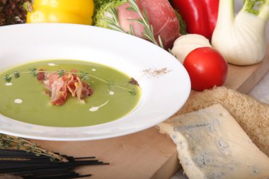 İtalyan çorbası, domuz pastırması ve tahta üzerinde sebzeler.