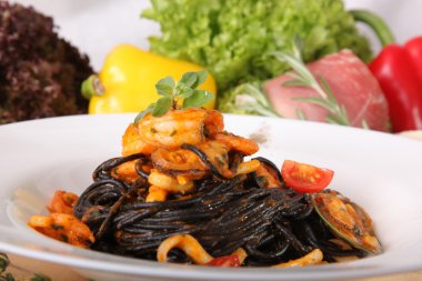 Black spaghetti with seafood on plate