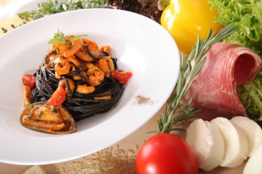Black spaghetti with seafood on plate