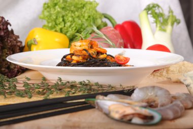 Black spaghetti with seafood on plate