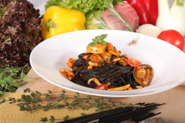 Black spaghetti with seafood on plate