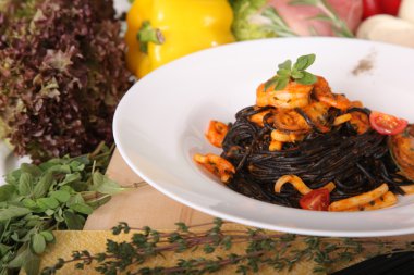 Black spaghetti with seafood on plate