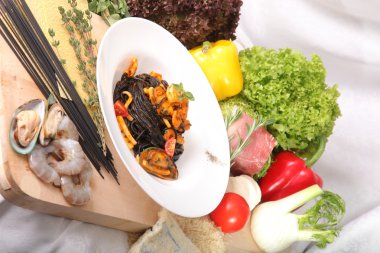 Black spaghetti with seafood on plate