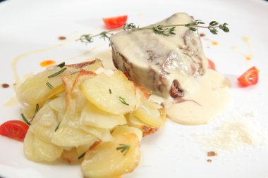 Soslu sığır eti ve tabakta patates.