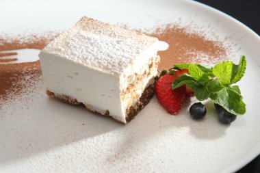 Tabağında böğürtlen olan tiramisu tatlısı.