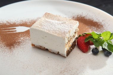 Tabağında böğürtlen olan tiramisu tatlısı.