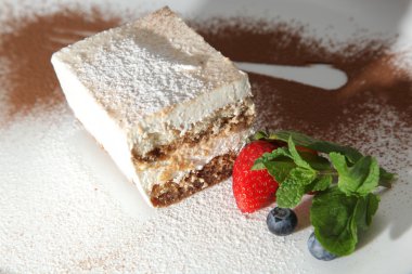 Tabağında böğürtlen olan tiramisu tatlısı.